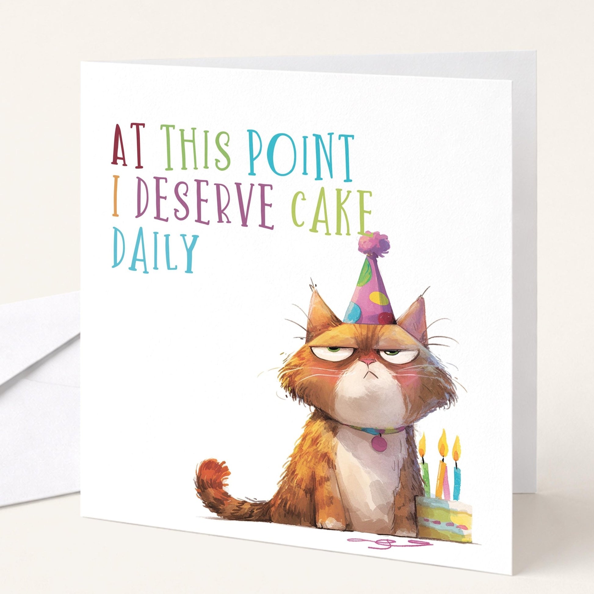 Funny cat birthday card from Whimsi Lilley featuring humorous text about deserving cake daily with a playful cat illustration.