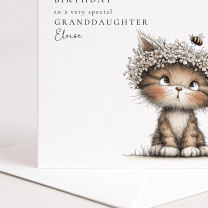 A birthday card featuring a cute kitten wearing a flower crown and looking up at the camera.