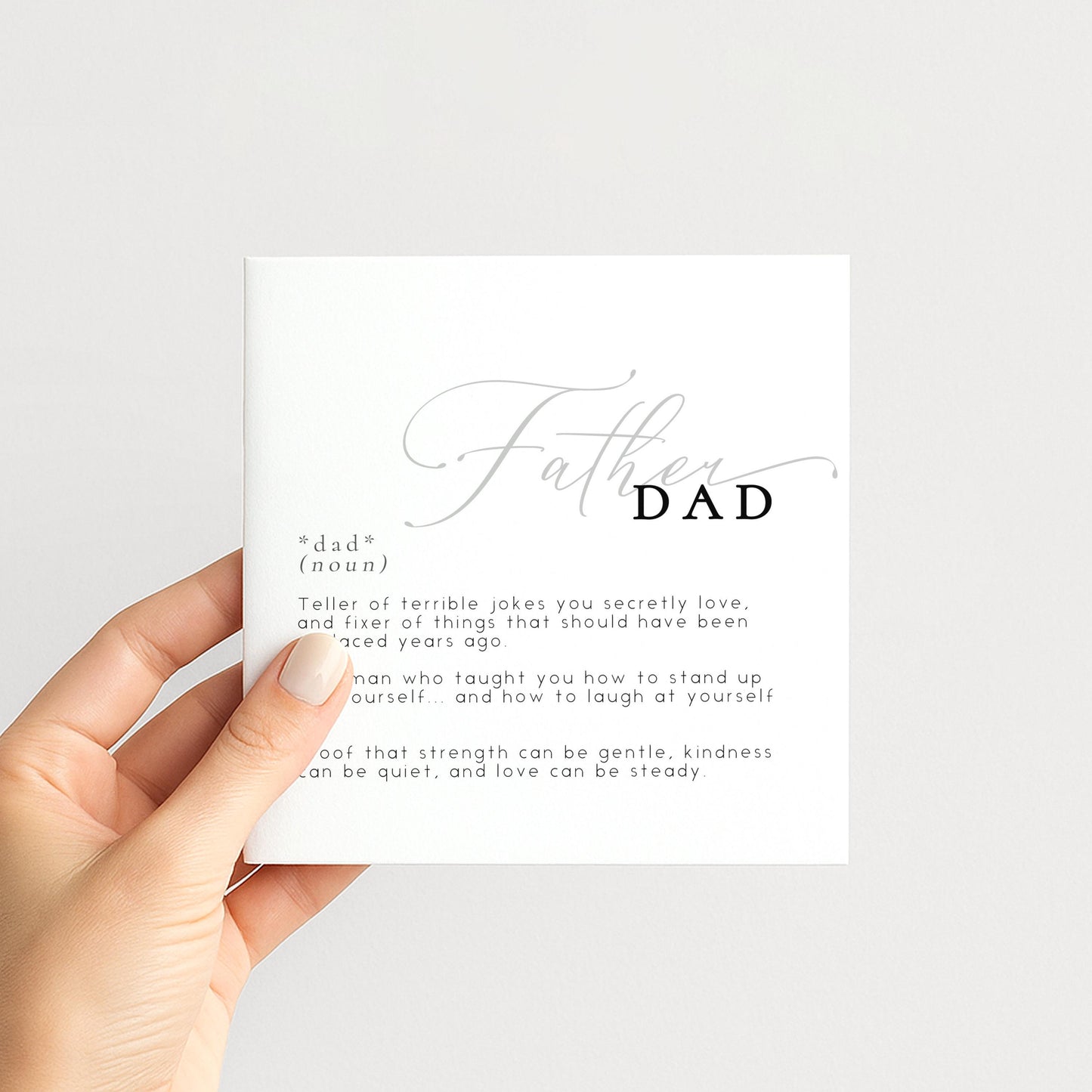 A hand holding a card with the word "DAD" written on it.