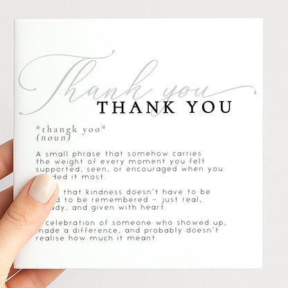 a hand holding a card with a definition of "Thank You" written on it.