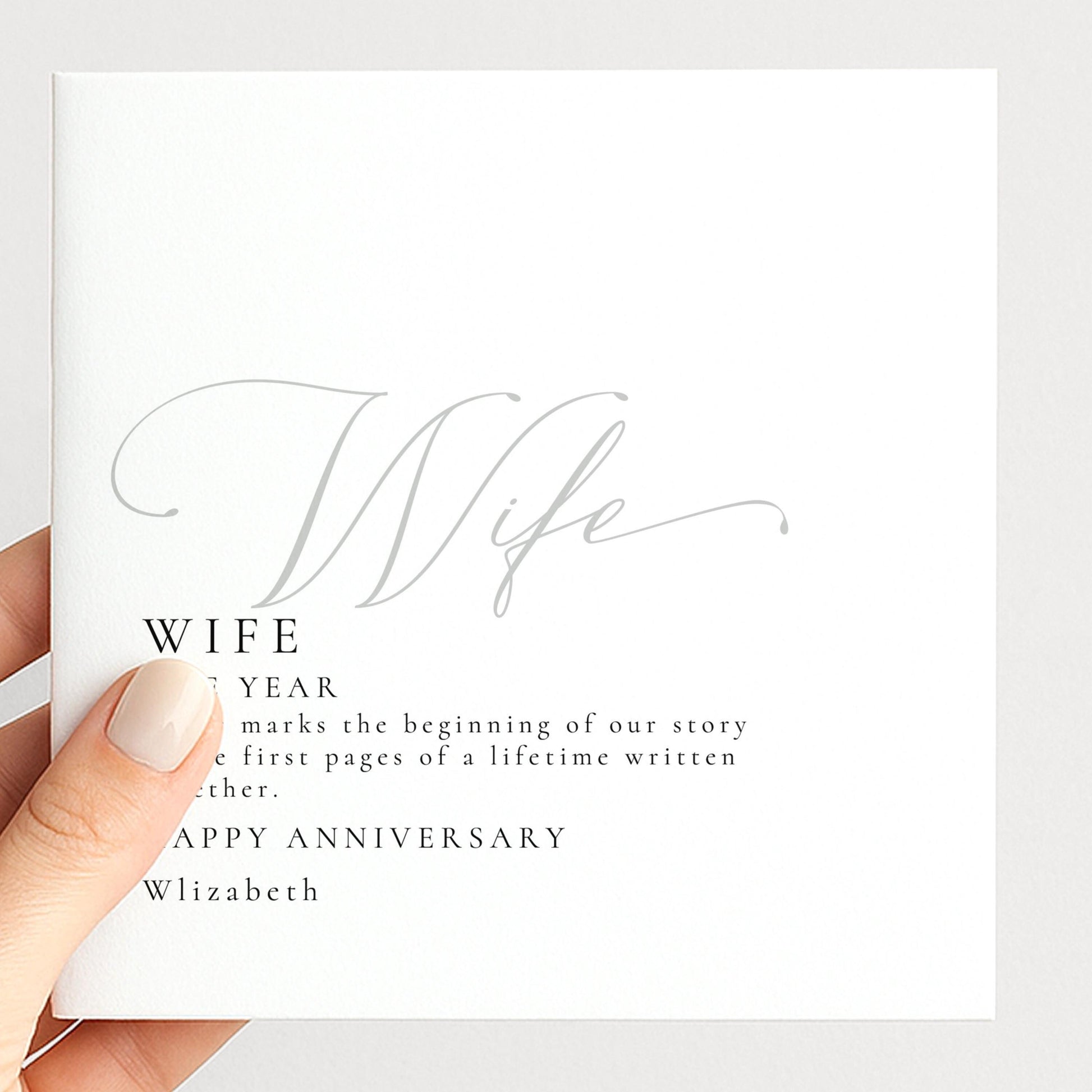 a person holding a white card with text and a cursive design.