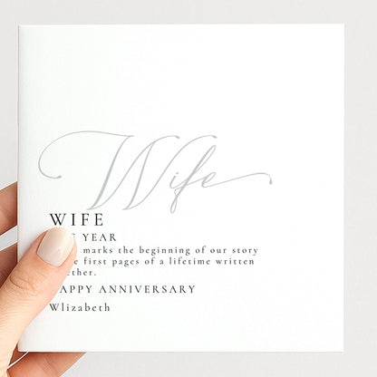 a person holding a white card with text and a cursive design.