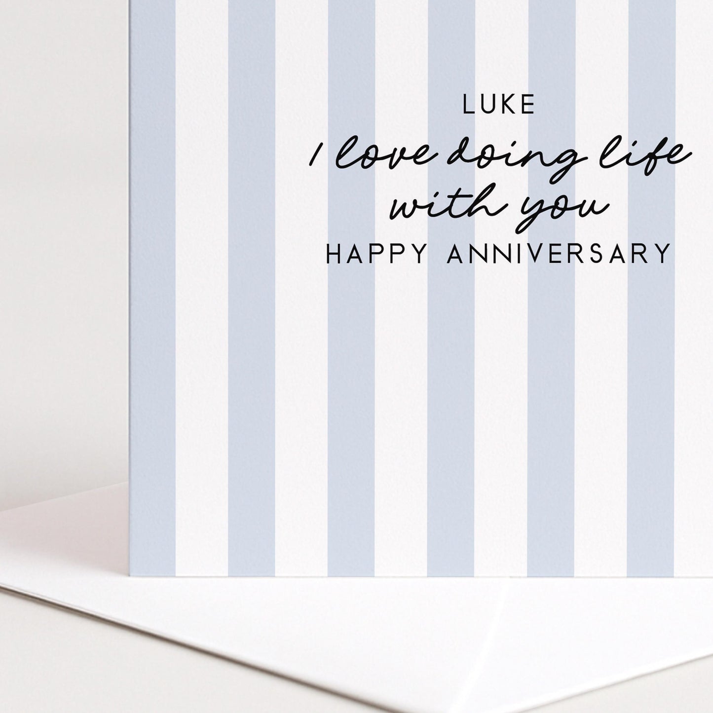 A personalised anniversary card with a soft blue stripe design and the sentiment I love doing life with you. Add a name!, printed on 300gsm card