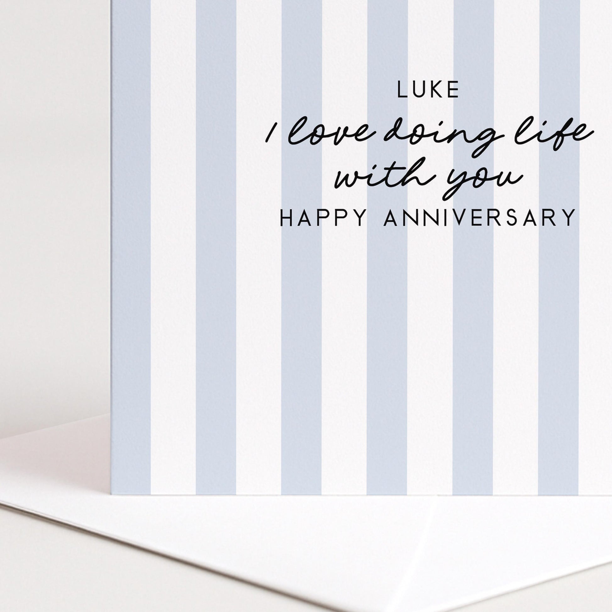 A personalised anniversary card with a soft blue stripe design and the sentiment I love doing life with you. Add a name!, printed on 300gsm card