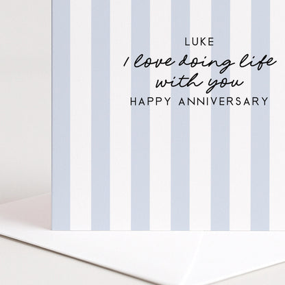 A personalised anniversary card with a soft blue stripe design and the sentiment I love doing life with you. Add a name!, printed on 300gsm card