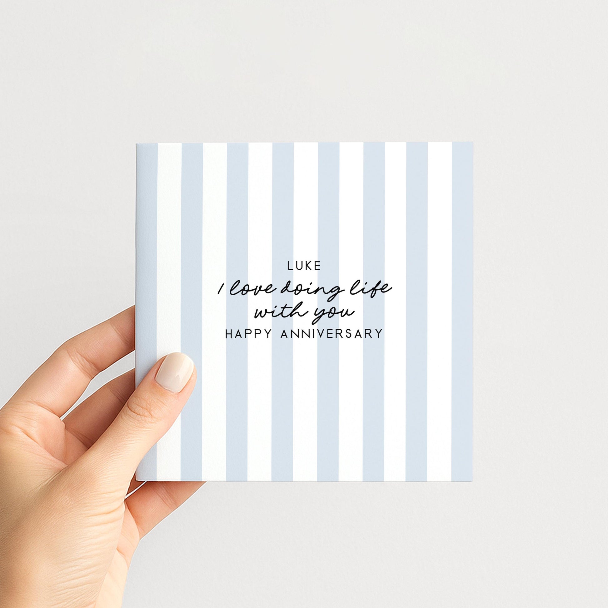 A personalised anniversary card with a soft blue stripe design and the sentiment I love doing life with you. Add a name!, printed on 300gsm card