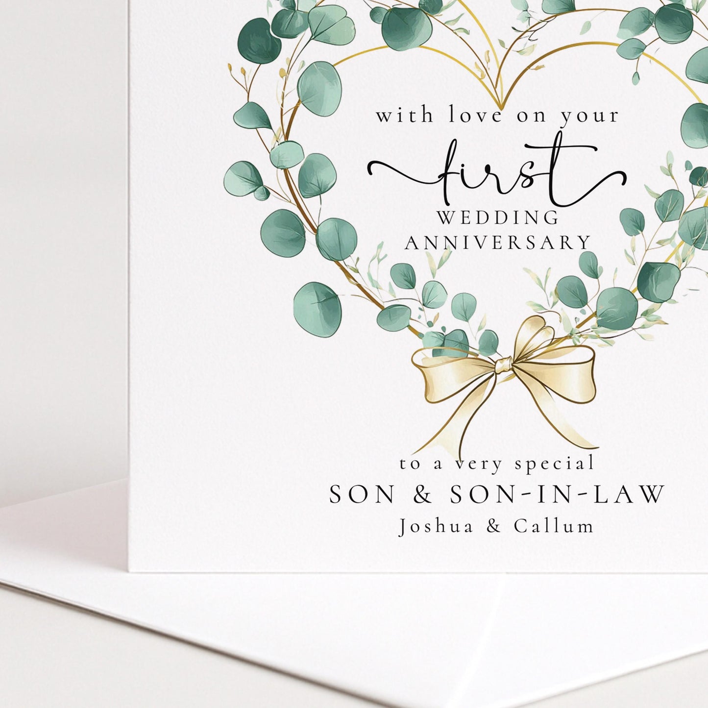 A personalised first wedding anniversary card for son and son-in-law featuring a beautiful eucalyptus heart wreath, printed on 300gsm card