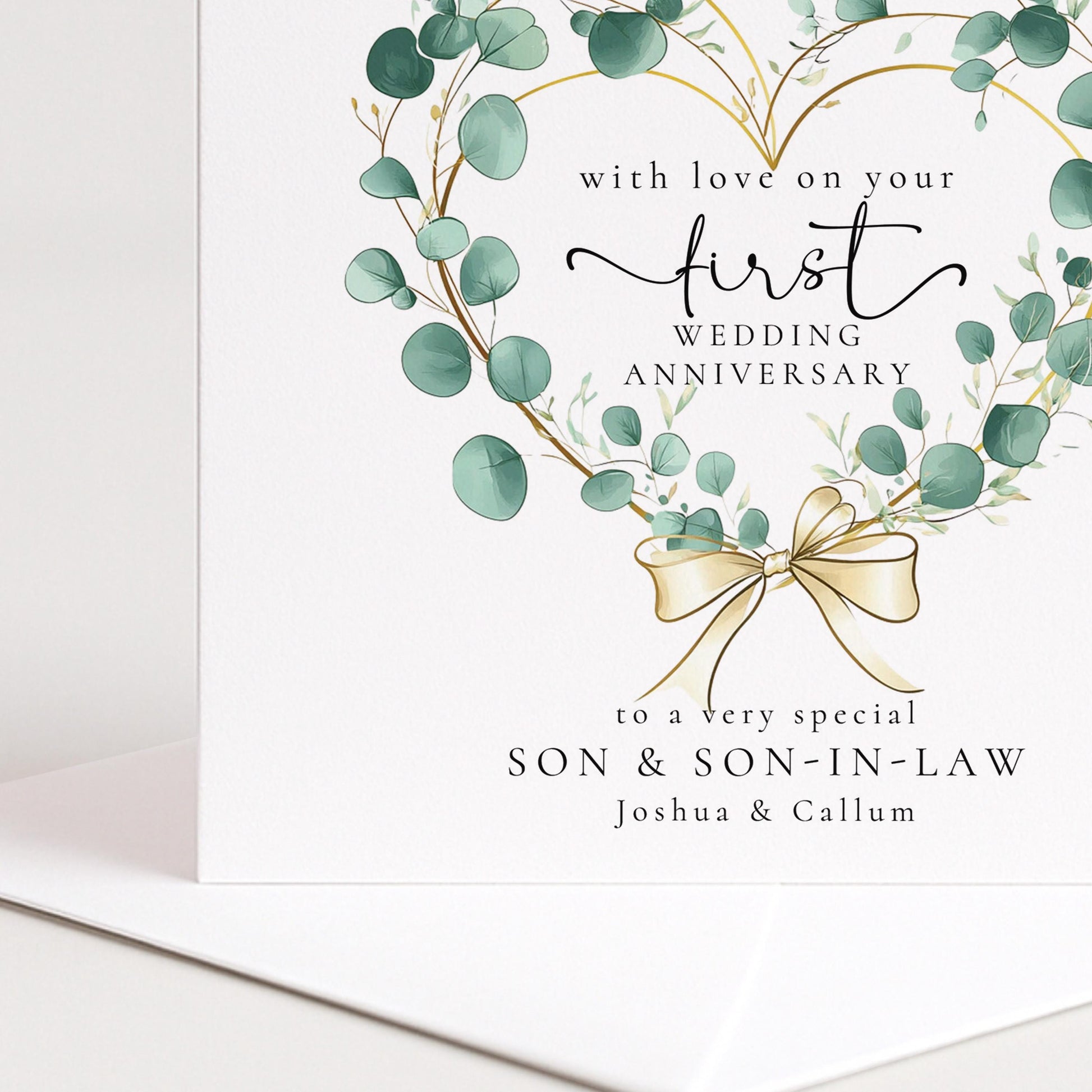 A personalised first wedding anniversary card for son and son-in-law featuring a beautiful eucalyptus heart wreath, printed on 300gsm card