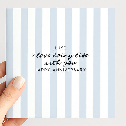 A personalised anniversary card with a soft blue stripe design and the sentiment I love doing life with you. Add a name!, printed on 300gsm card