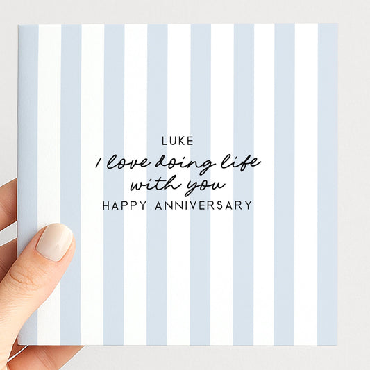 A personalised anniversary card with a soft blue stripe design and the sentiment I love doing life with you. Add a name!, printed on 300gsm card