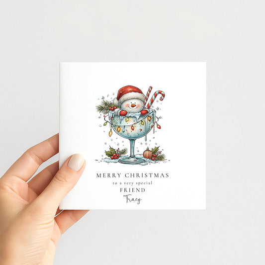 Personalised funny Christmas card for friend with snowman in martini glass illustration and name, printed on 300gsm card